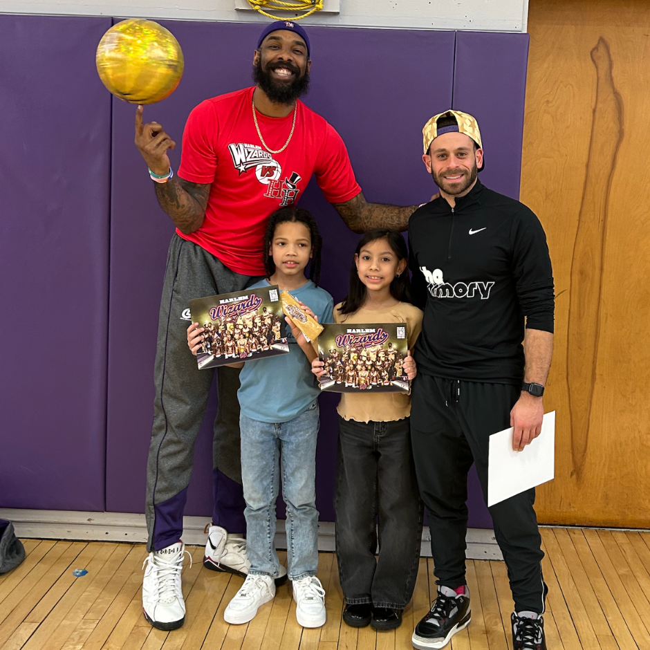four people and one holding a basketball 