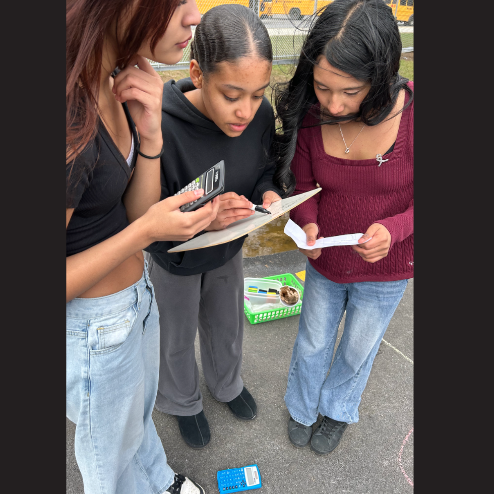 three students holding calculator and white board 