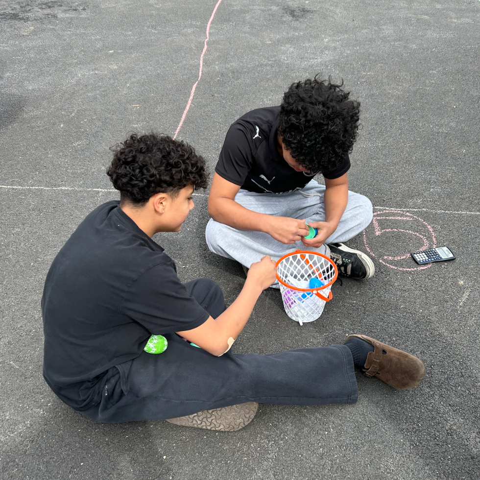 two students cracking plastic eggs 