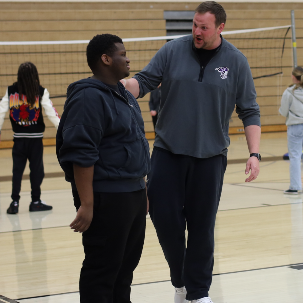 two men standing by volleyball net