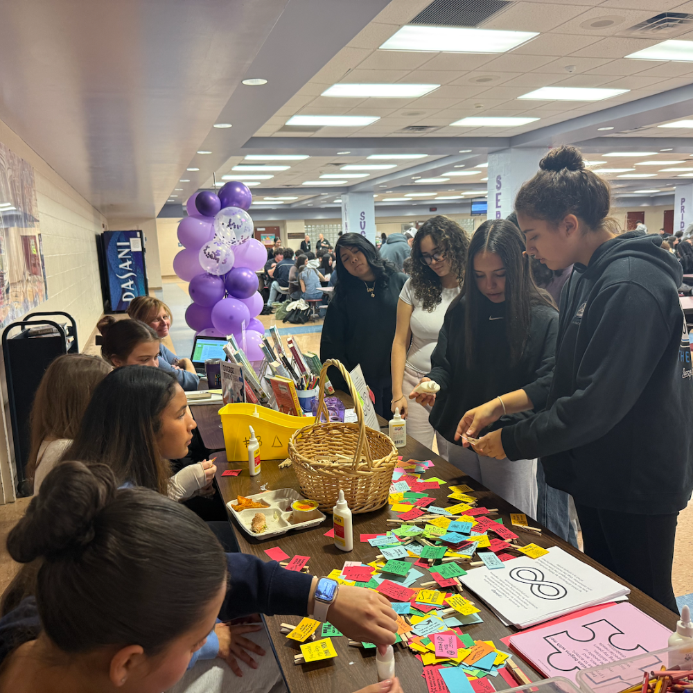 Students standing in front of a table with a basket 