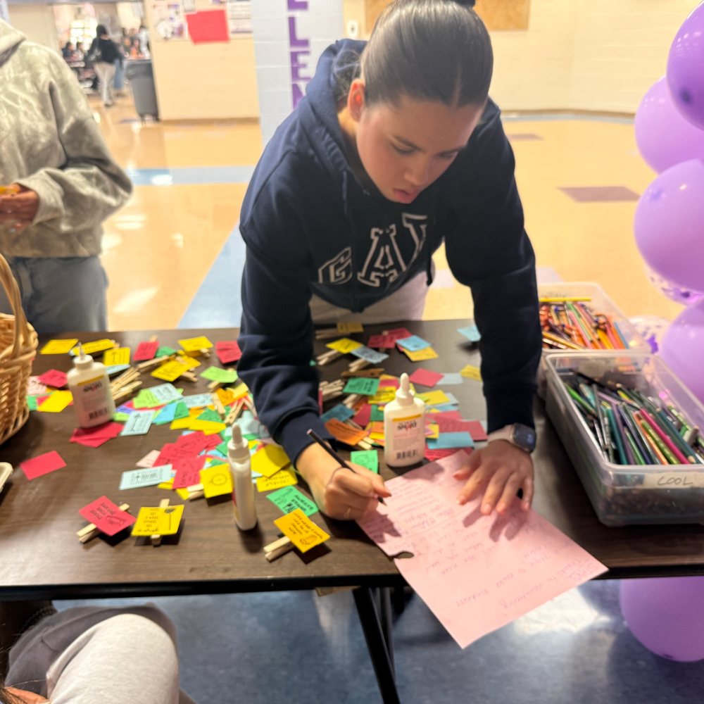 student writing a note on a table 