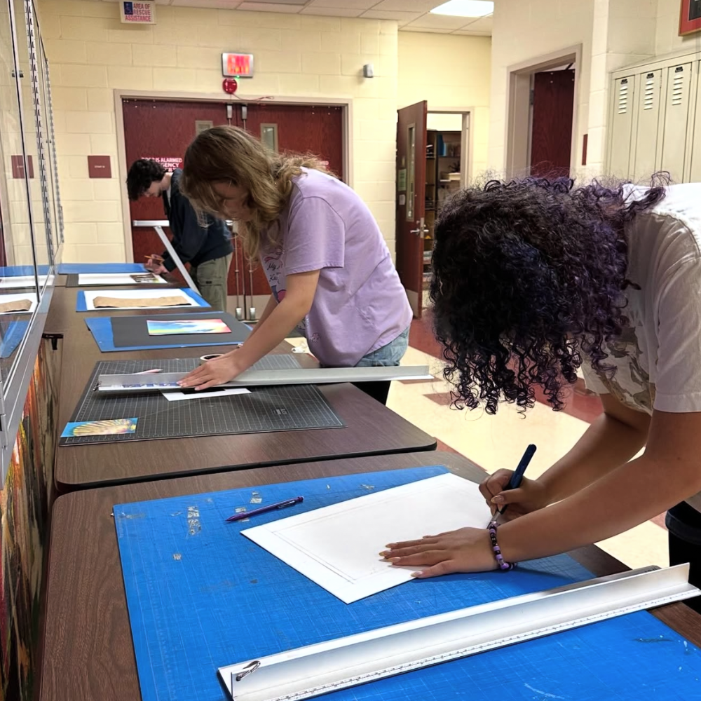 students measuring paper on an art table 