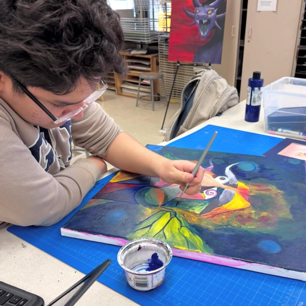 student painting a picture leaning on a table 