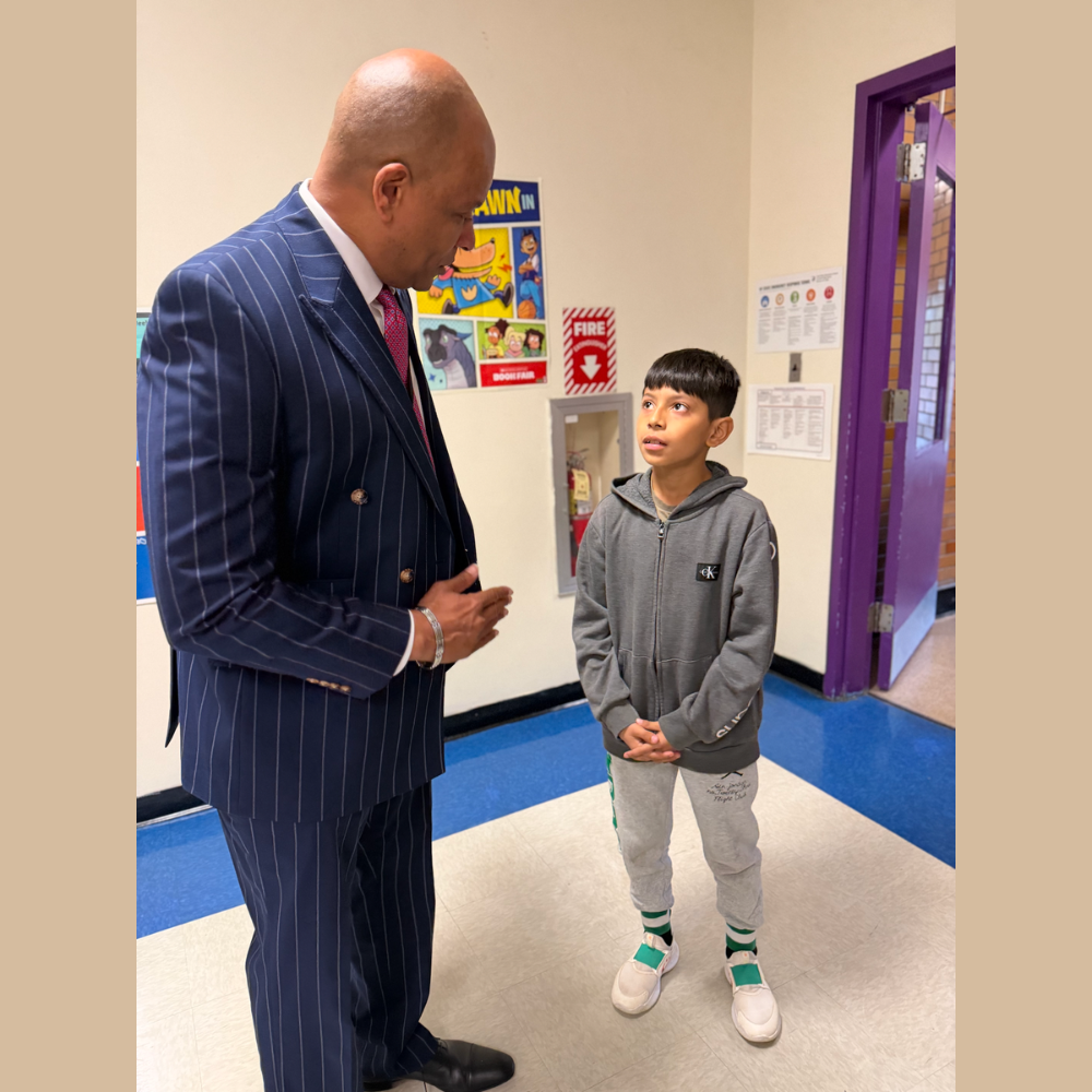 man standing with a student in a hallway 