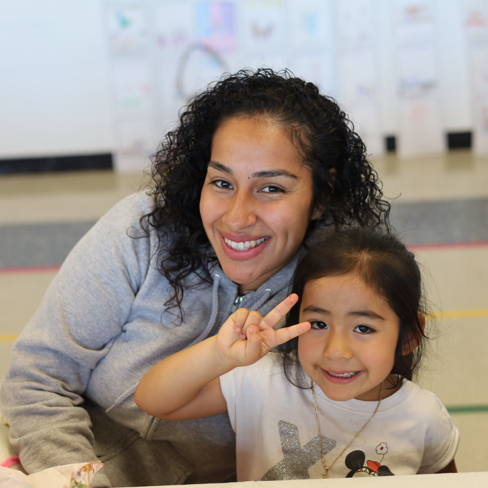 woman with child with two fingers up 