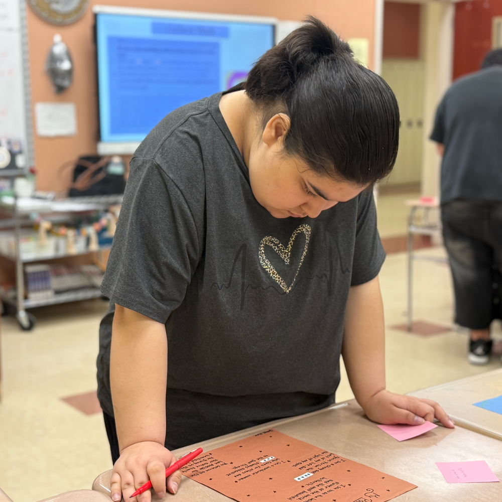 student standing next to desk 