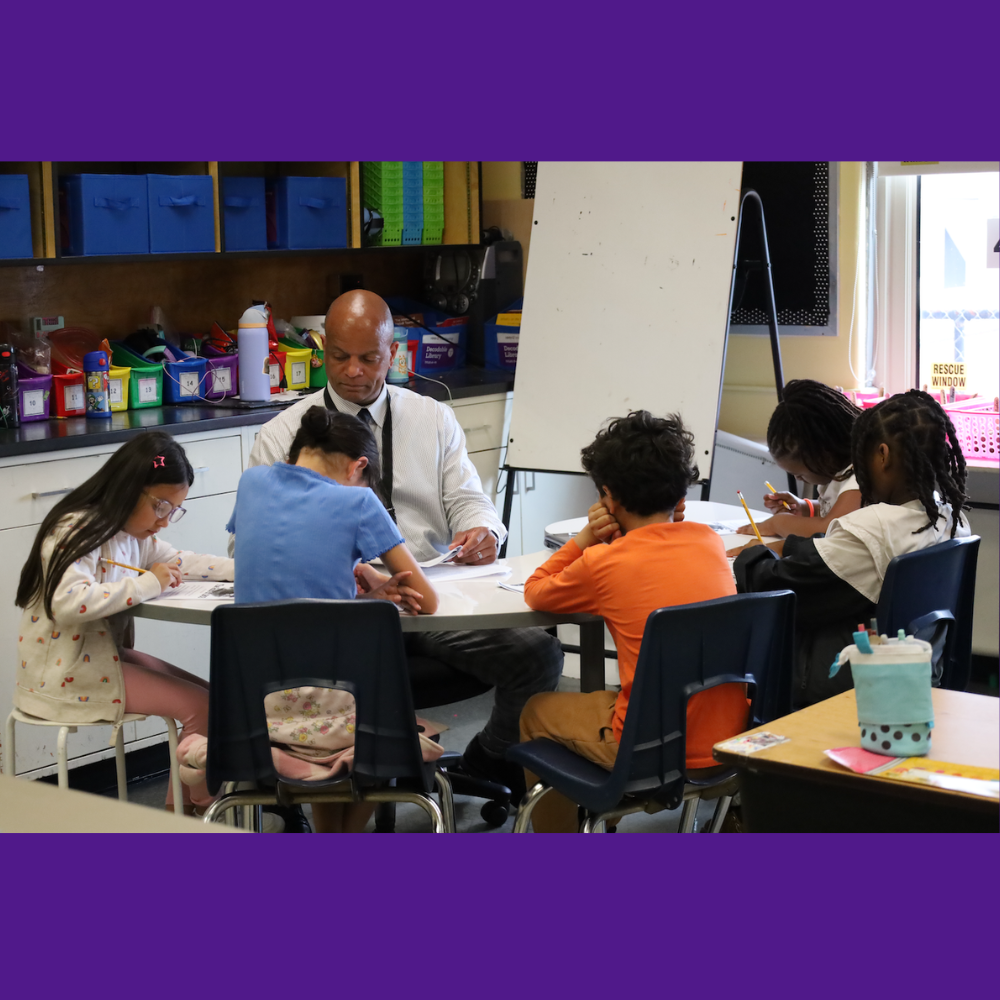 students sitting at small table 