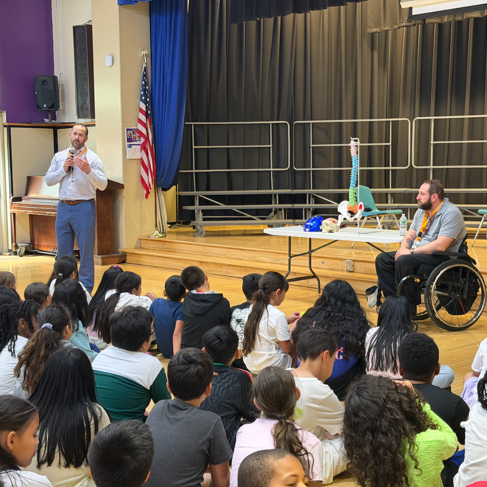 students sitting on floor, man in wheelchair