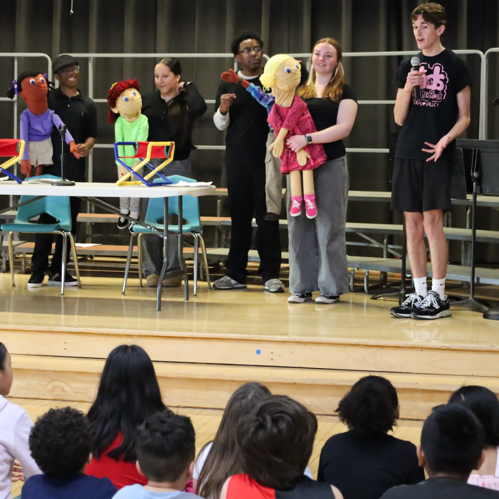 students standing with puppets