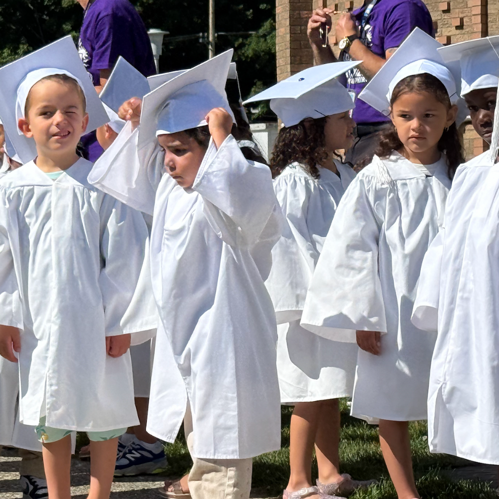 students wearing all white caps and gowns
