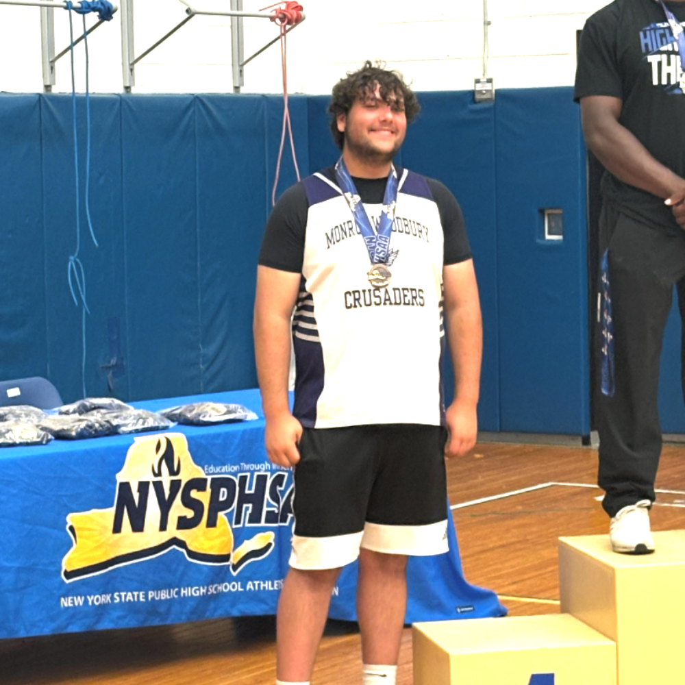 student wearing a medal with a monroe-woodbury crusaders shirt