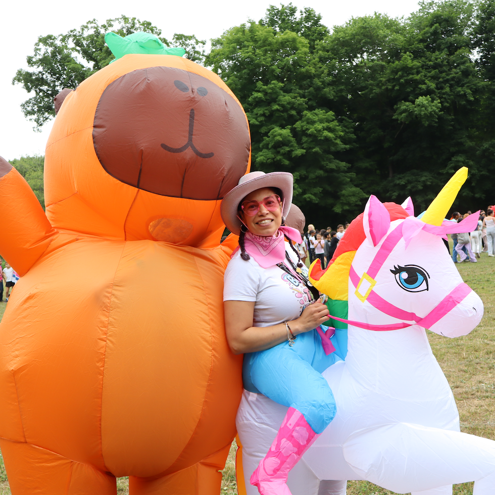 capybara and unicorn costume with woman with hat and sunglasses