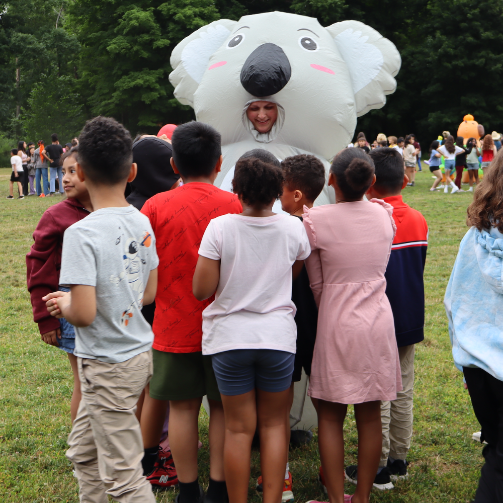 person in a koala costume with children around