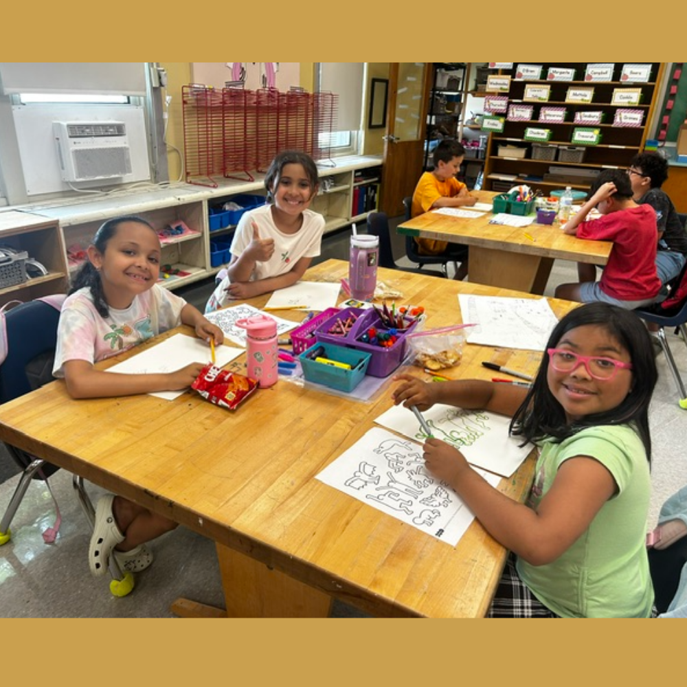 students sitting at an art table coloring