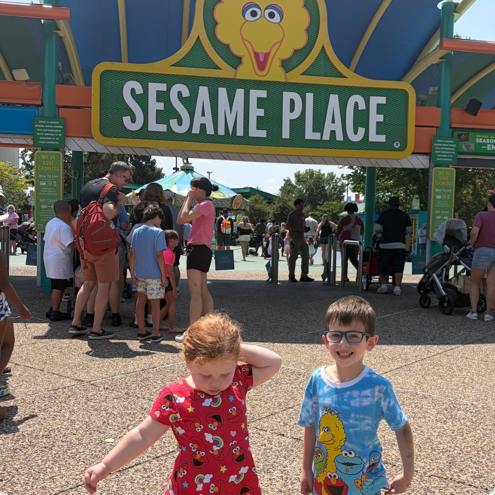 sesame place, two children wearing colorful shirts 