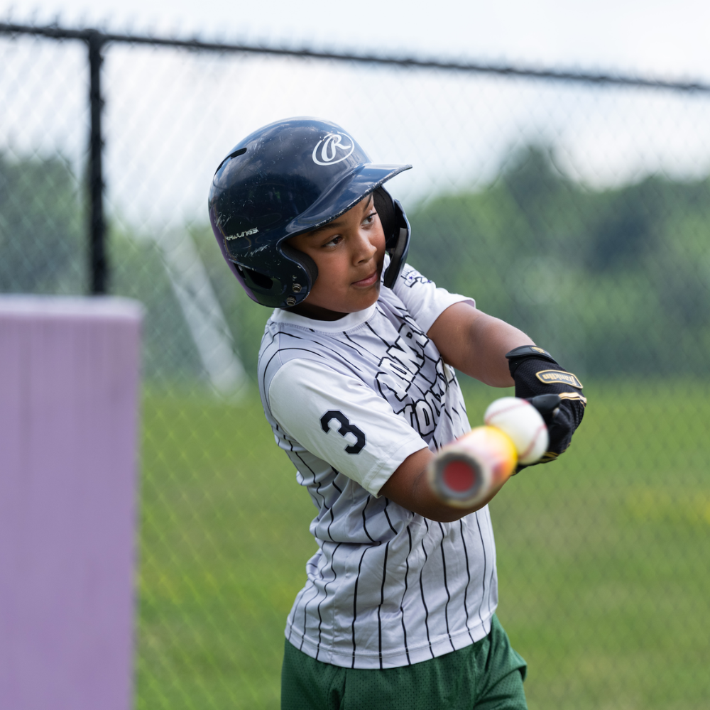 student swinging a baseball bat 