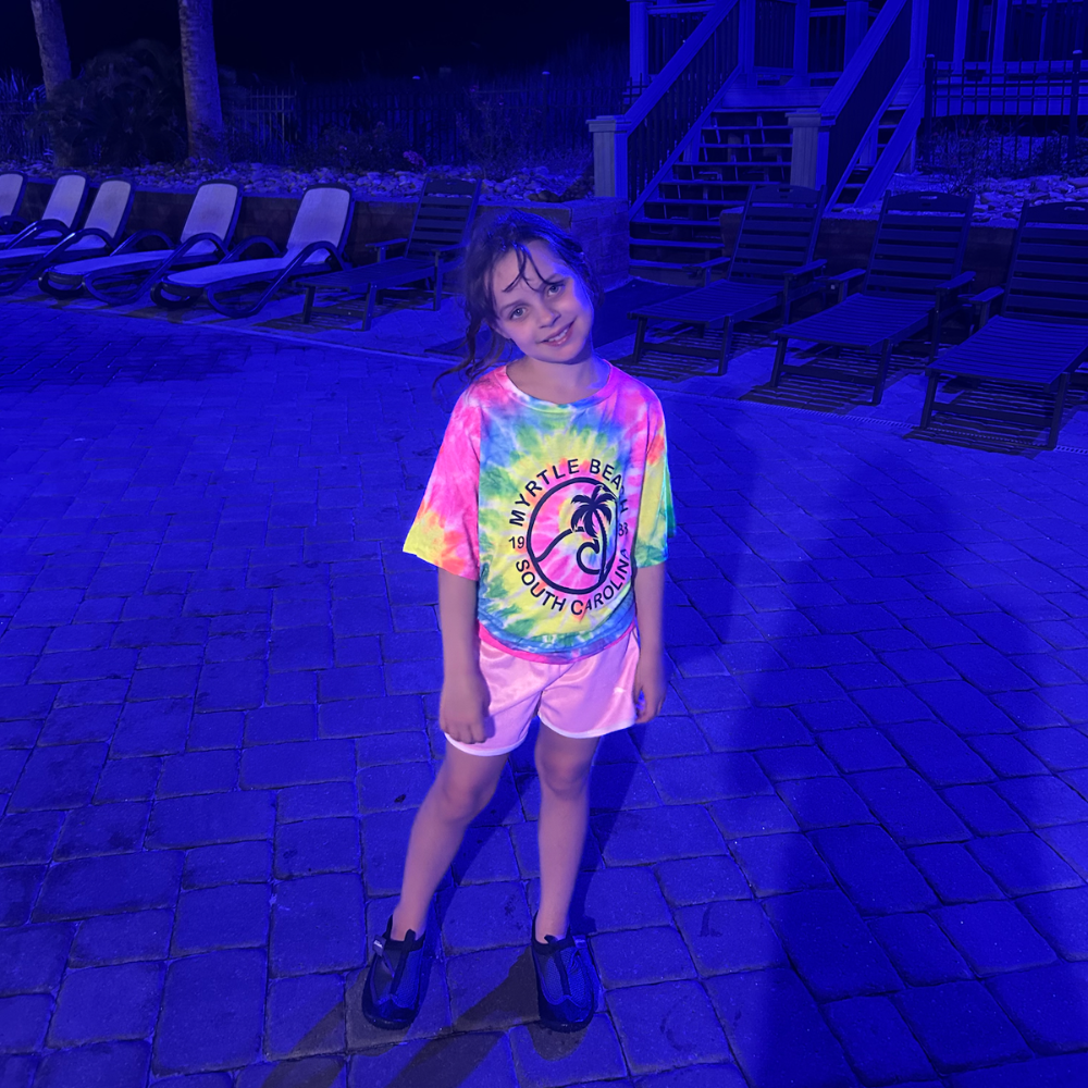 Girl with tie-die shirt that says Myrtle Beach 