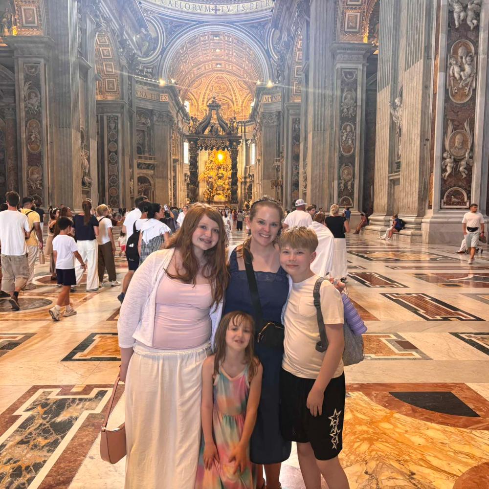 four people standing in a cathedral