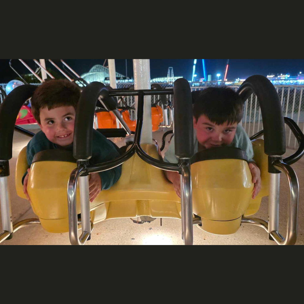 two students on a yellow roller coaster