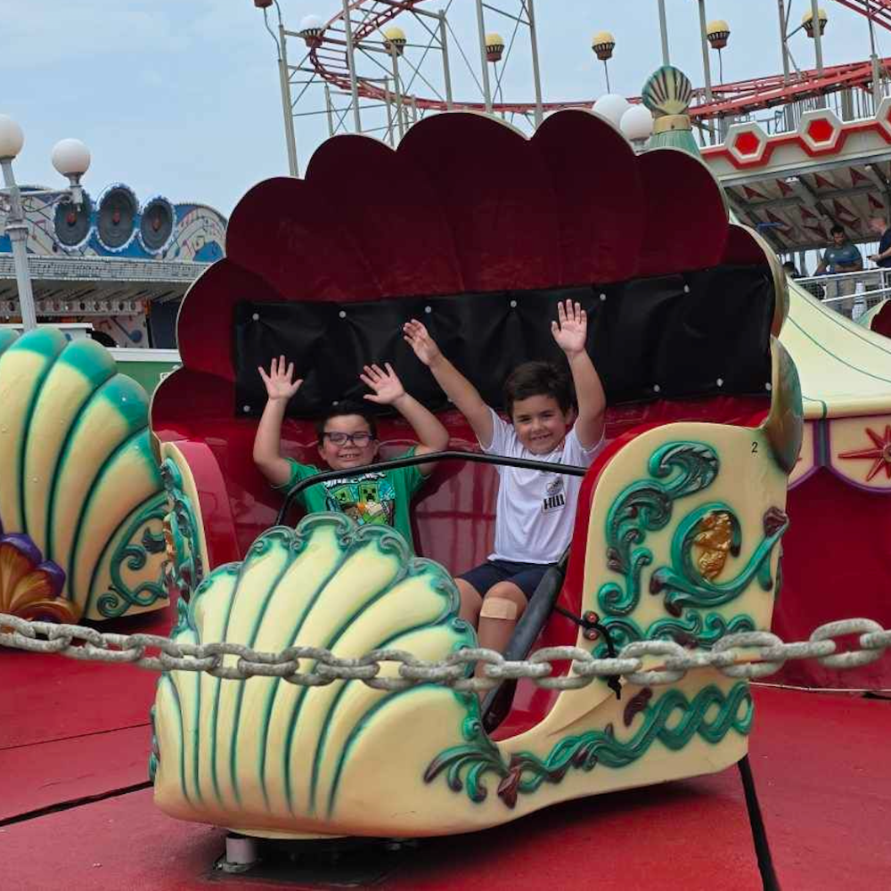two students on a roller coaster with a seashell