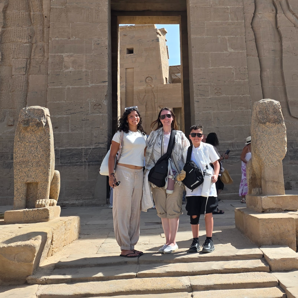 three people standing in between two statues