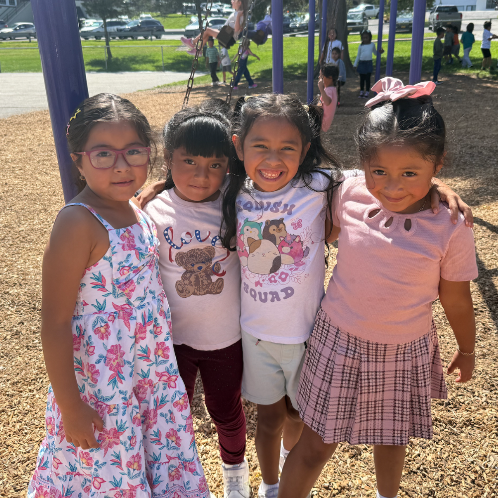 four students standing in playground