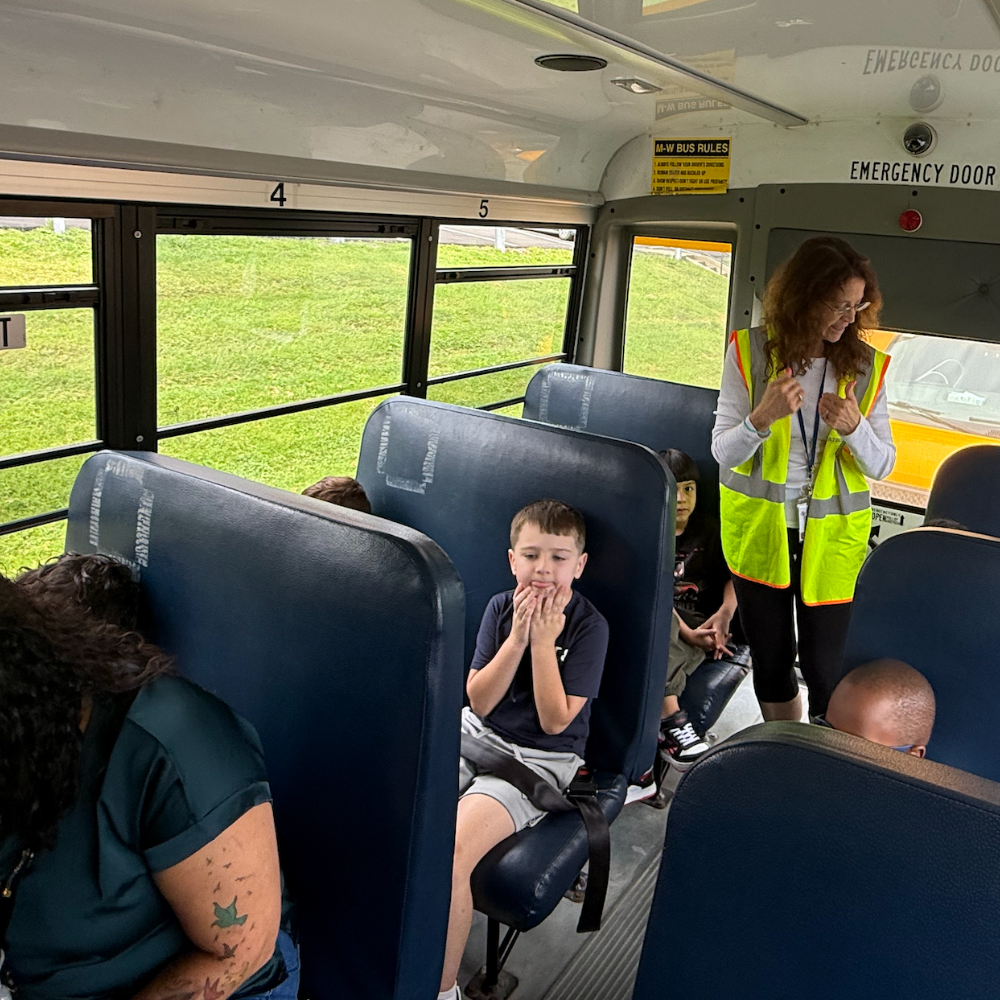 teachers with students on a bus next to emergency door