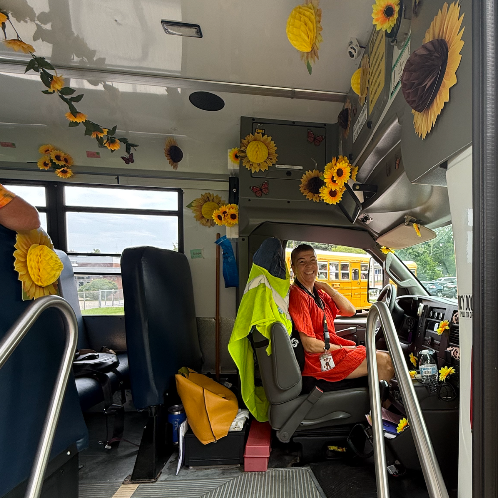 woman on a school bus with paper sunflowers