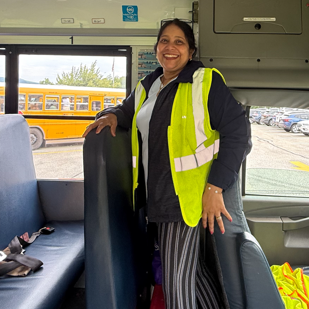woman with a green vest standing on a bus