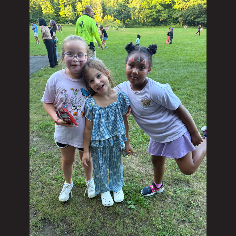 three students wearing pink, blue and with faces painted like a unicorn
