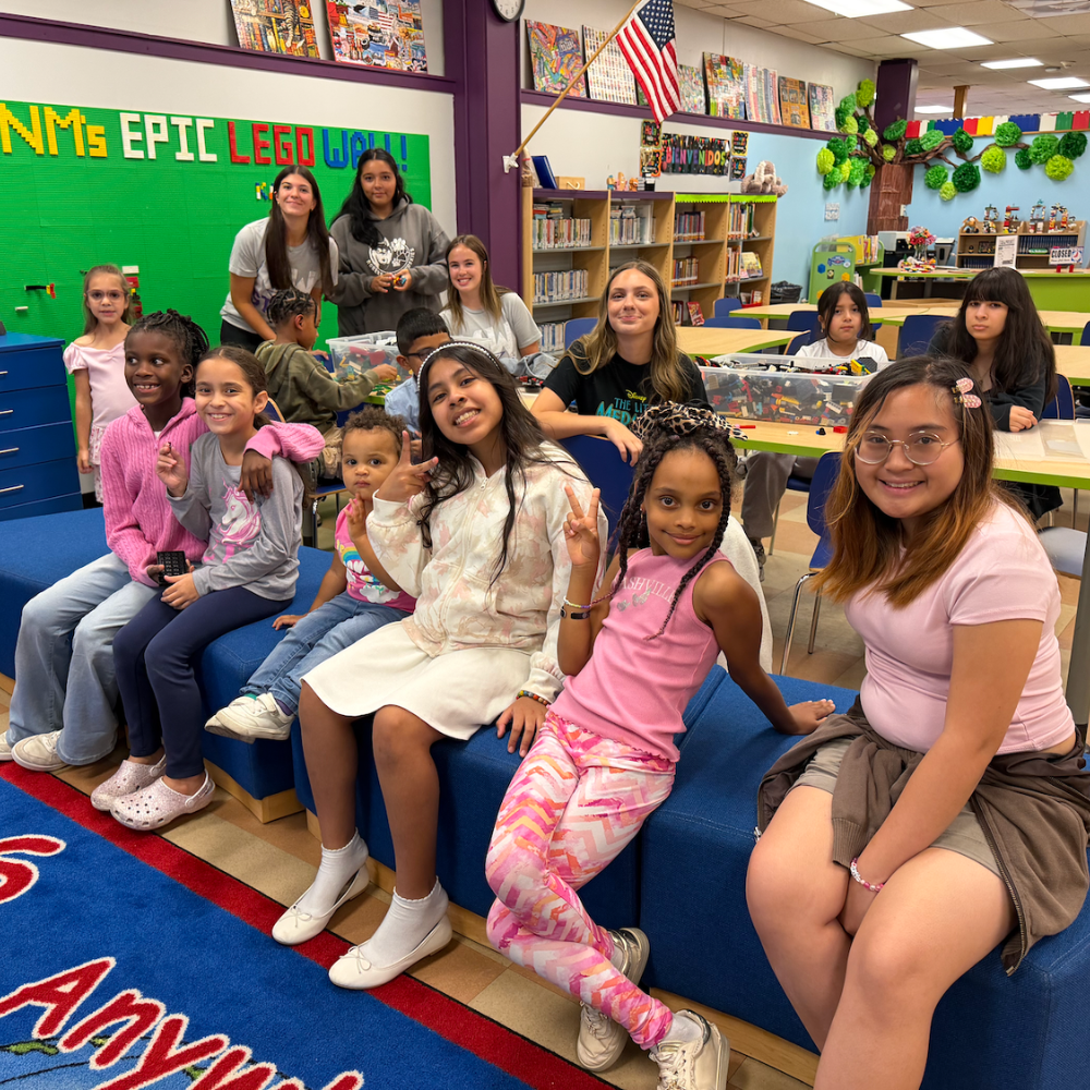 students sitting in a library on a blue couch 