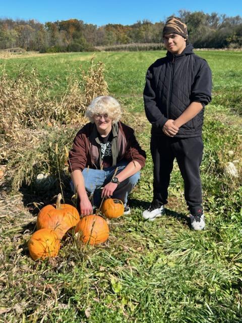 students with pumpkins at pumpkin patch