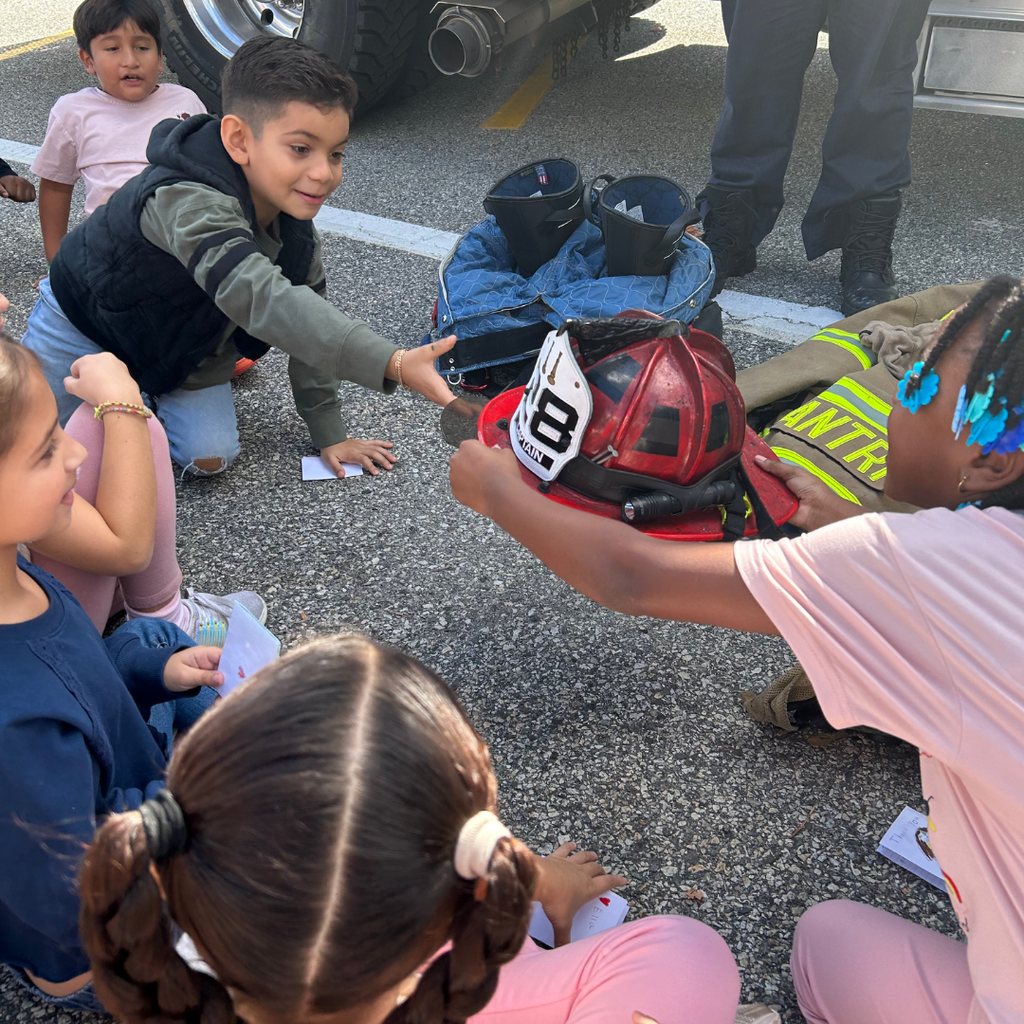 students passing around a fire fighters hat 