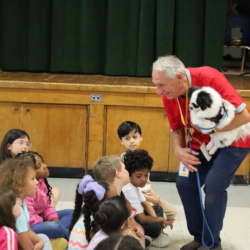 man with dog standing over children