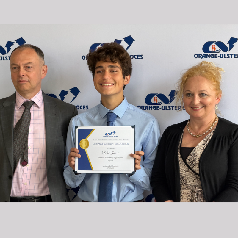 photo of three people, one holding a certificate