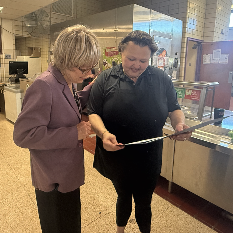 Cemile and Director of Food Services look at her award