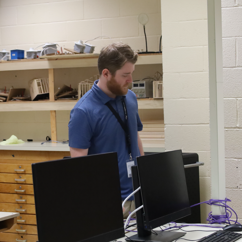 student with a blue shirt looking at a computer