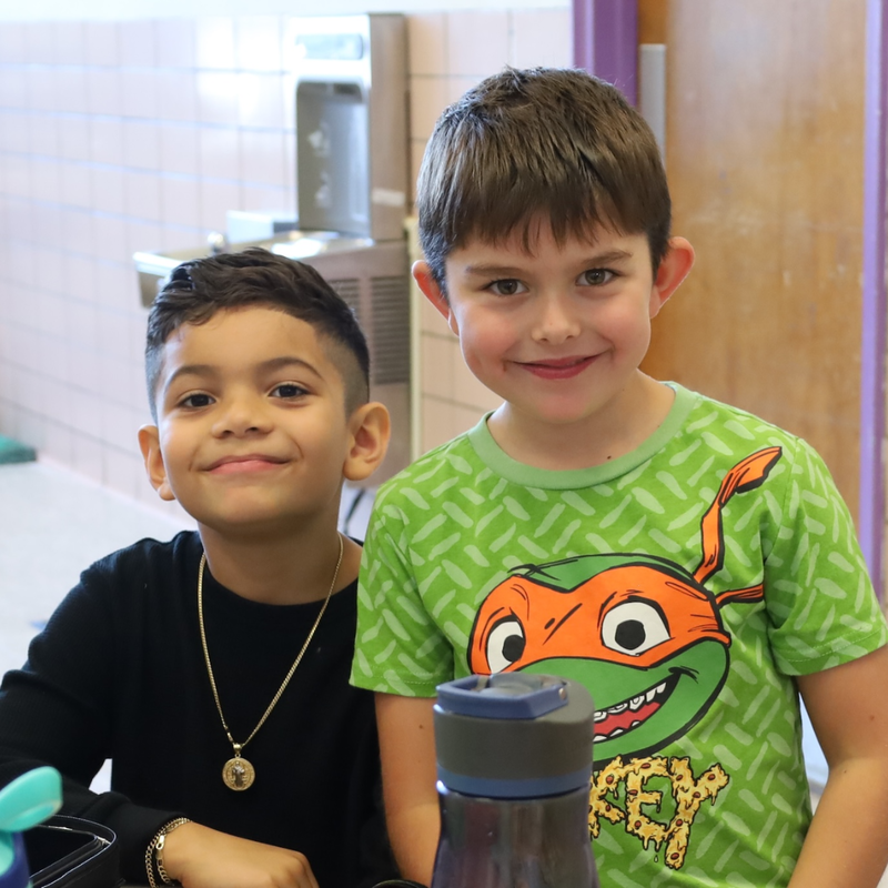 two boys, one wearing ninja turtle shirt smiling