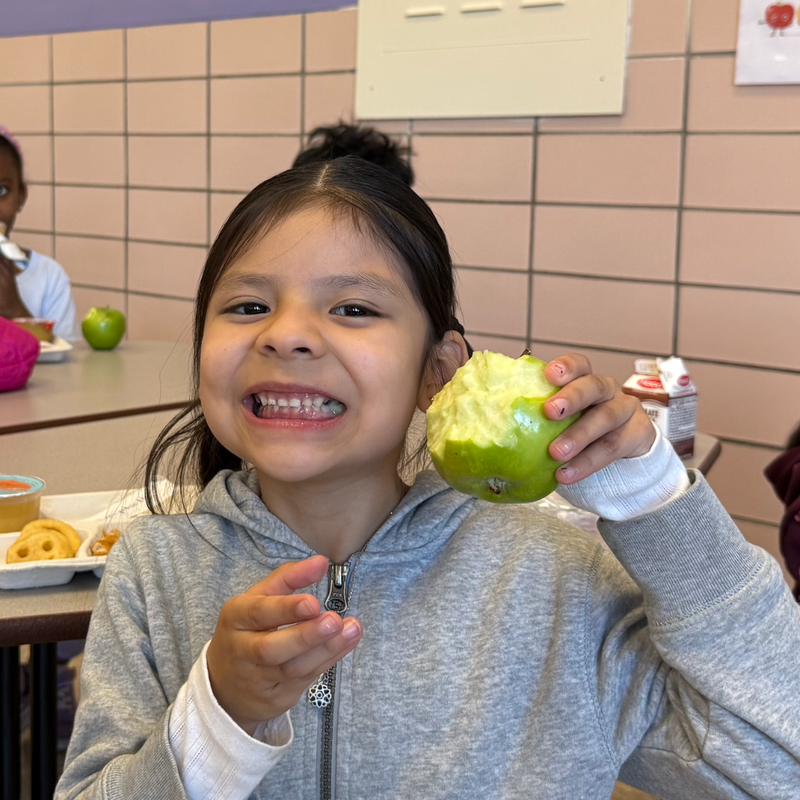 Student holding a green apple
