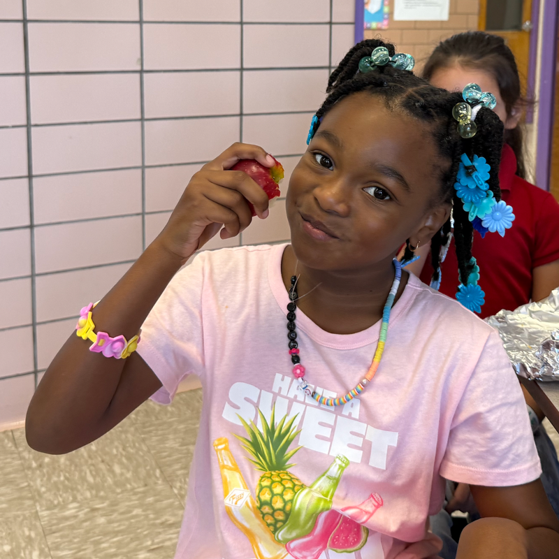 one girl eating an apple smiling