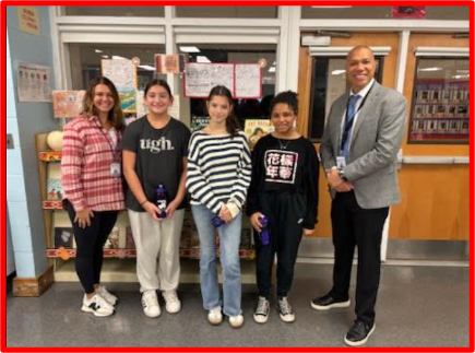 five people standing in a library 
