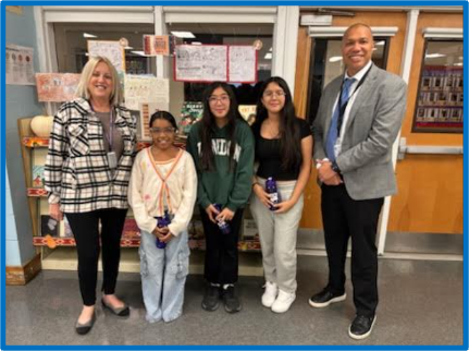 five people standing in a library 