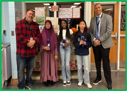 five people standing in a library