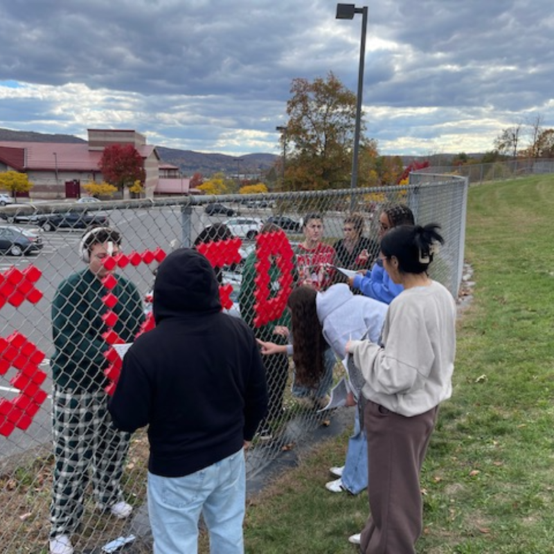 students decorating a fence red