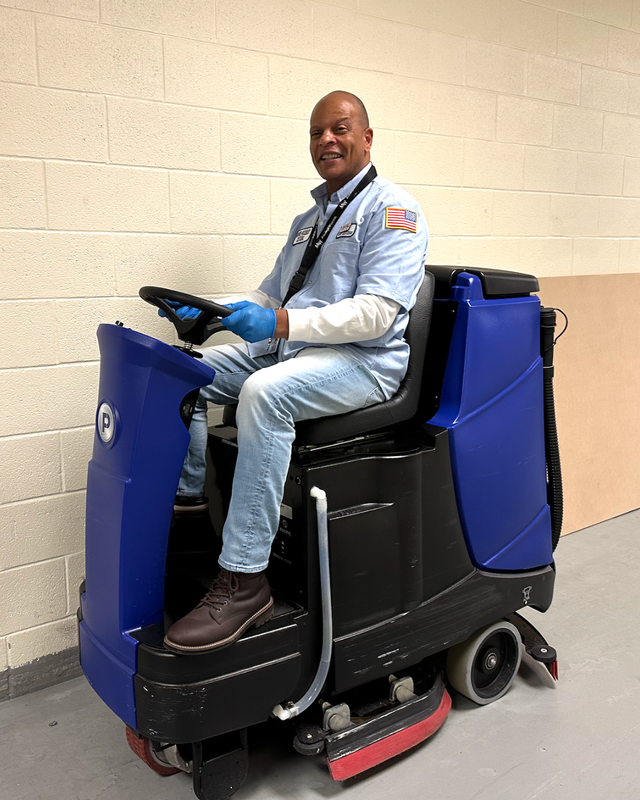 man sitting on a blue zamboni