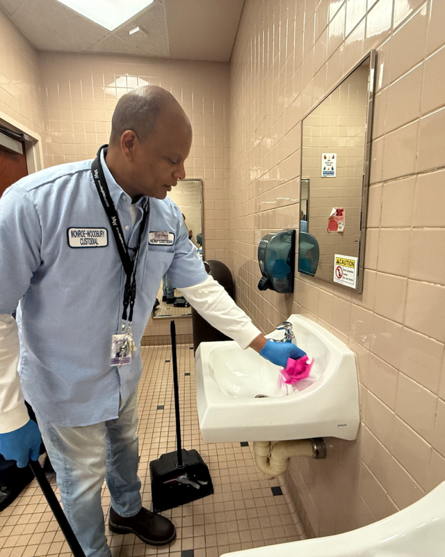 man cleaning a white sink