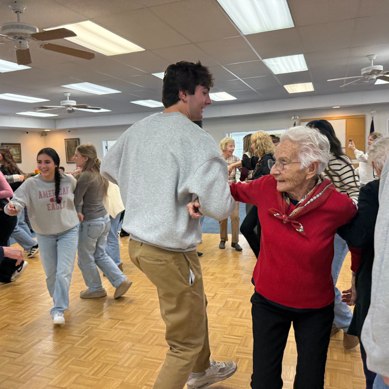 woman with red shirt dancing with man with grey shirt