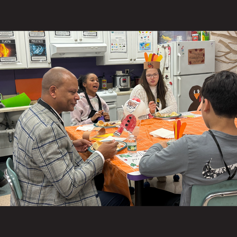 people sitting at an orange table eating