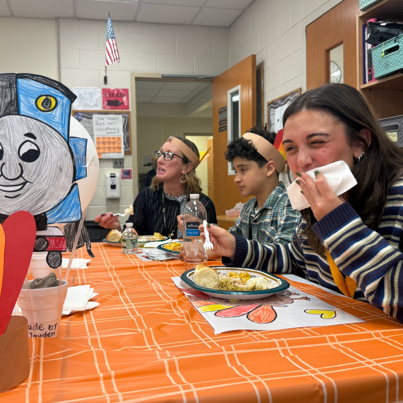 woman wiping her face laughing while eating